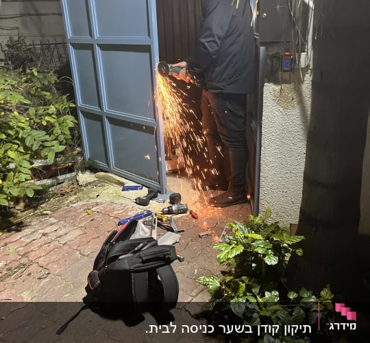 אדם חותך דלת מתכת עם דיסק חשמלי
